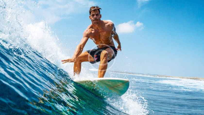 A man riding on top of a surfboard in the ocean.