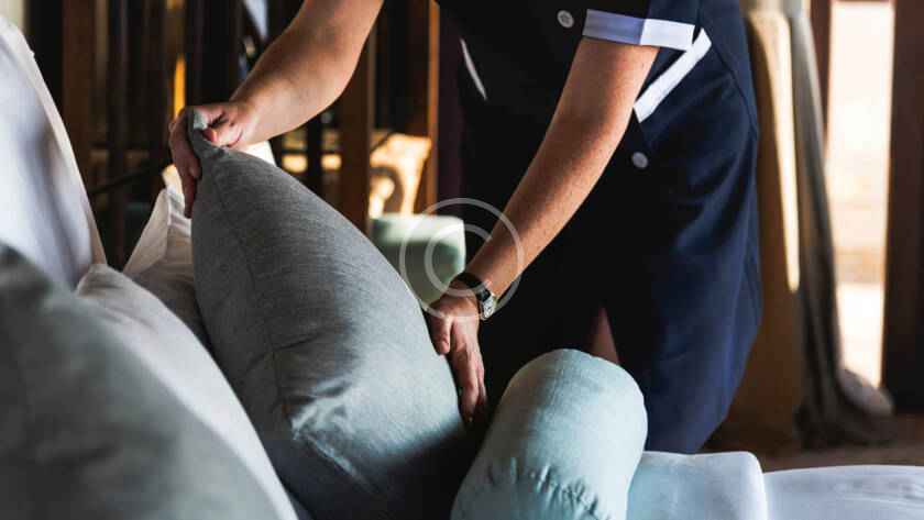A person is holding pillows in their hands.