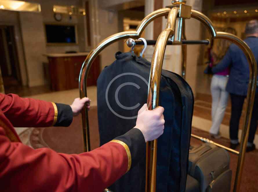 A person holding onto luggage on top of a rack.