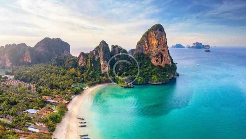 A beach with boats and mountains in the background.