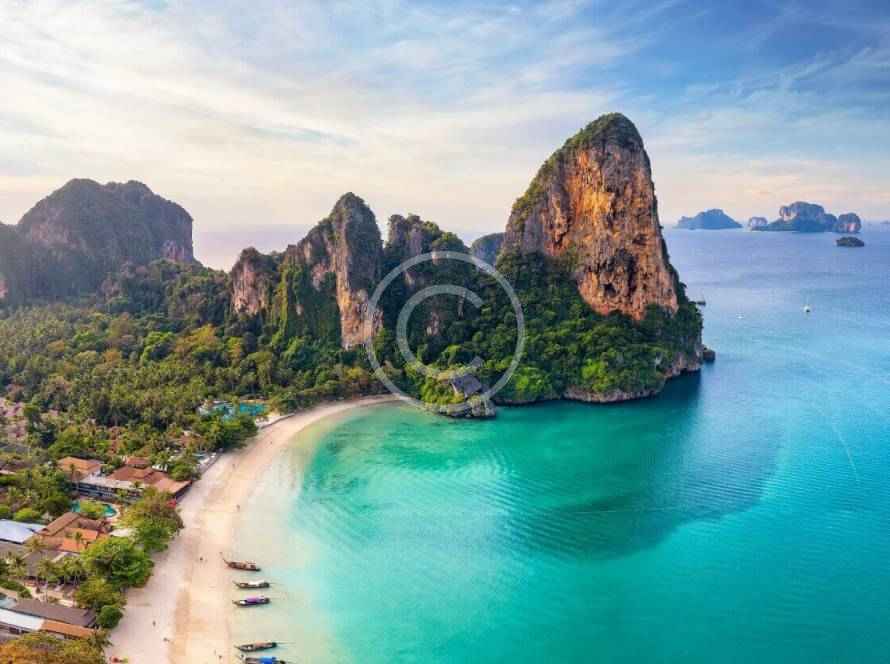 A beach with boats and mountains in the background.