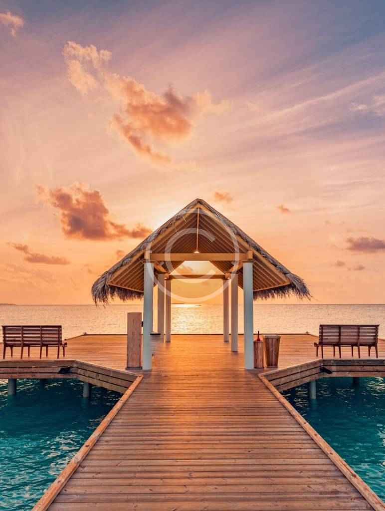A dock with benches and an umbrella over the water.