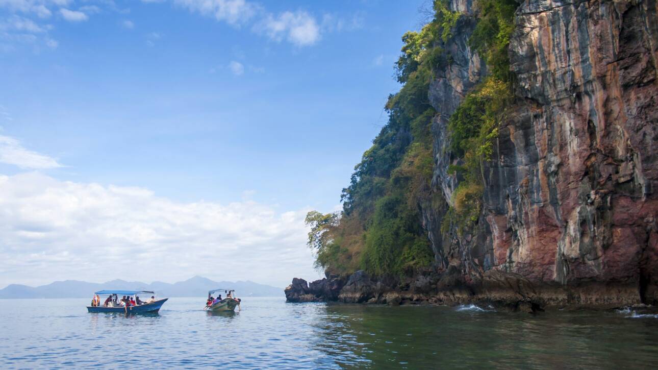 Perfect vacation in Langkawi, Malaysia. Tourist boats in the sea exploring the scenery.