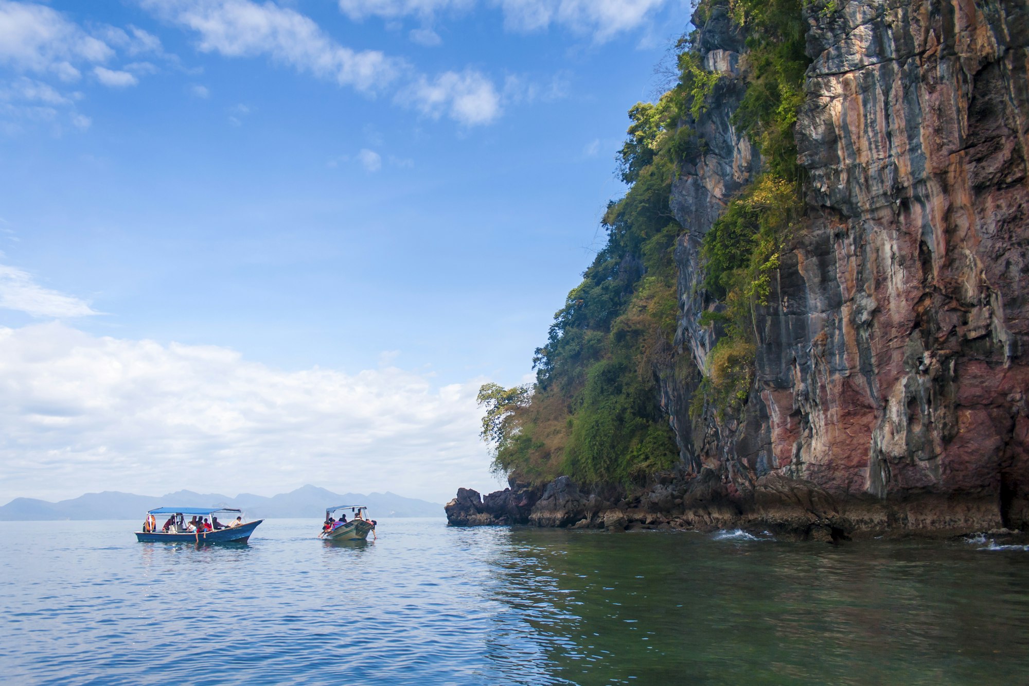 Perfect vacation in Langkawi, Malaysia. Tourist boats in the sea exploring the scenery.